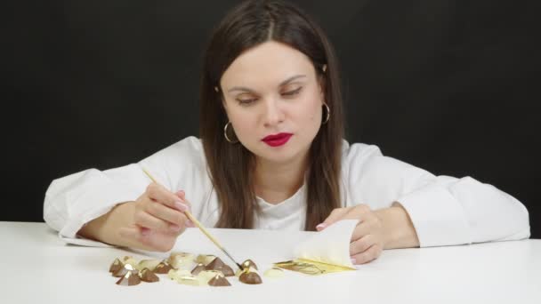 Jolie confiserie féminine décorer bonbons au chocolat premium avec feuille d'or — Video