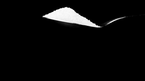 Zahărul din trestie albă care cade din linguriță izolată pe mișcarea lentă neagră — Videoclip de stoc