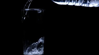 Saf içme suyu, plastik şişeden izole edilmiş ağır çekime dökülüyor.