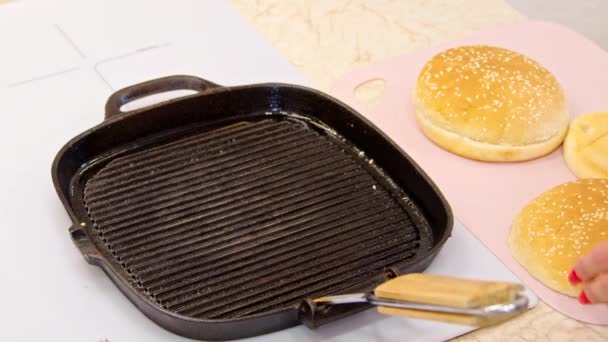Close up cucina femminile stendere panini hamburger di sesamo sulla padella griglia, pasto gustoso — Video Stock