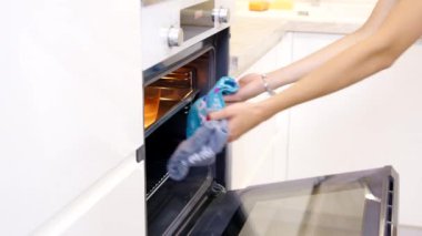 Kadınların elleri fırından peynirli kızarmış domuz pastırması çıkarır. Hamburger pişiriyorum.