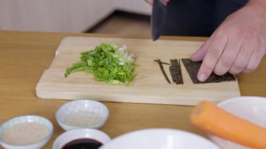 Kapalı erkek aşçı Nori kuru deniz yosunu örtüsünü, sağlıklı yemek malzemelerini keser