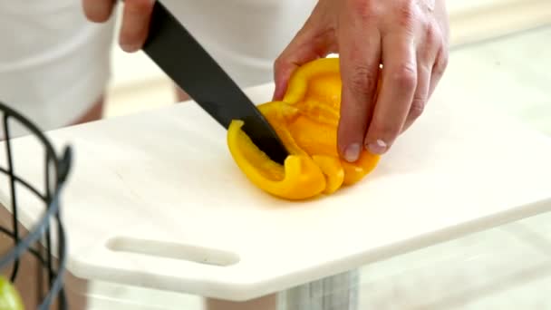 Close up macho cozinheiro corta pimentão amarelo fresco em fatias, homem cozinhar refeição vegan — Vídeo de Stock