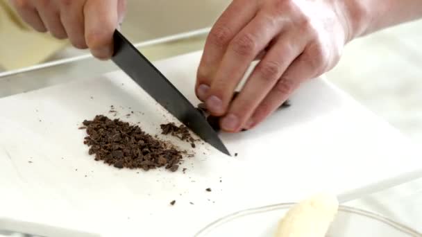 Chef tranches de chocolat pour la fabrication de muffins au chocolat, tarte ou produits de boulangerie — Video