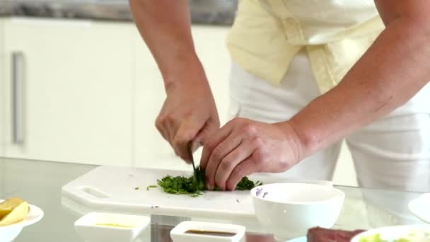 Fermer homme cuisine à la maison, coupe persil frais pour vinaigrette sur la cuisine — Video