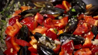 Yakın plan sebzeler ve midyeler buharla tavada kızartılmış, paella hazırlıyorlar.