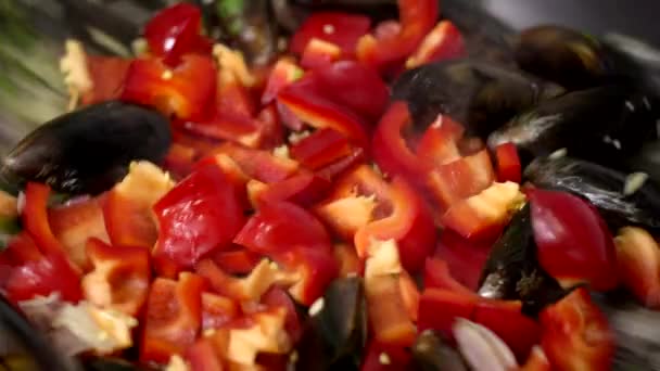 Κοντινά λαχανικά και μύδια με σκόρδο τηγανισμένα σε τηγάνι, ετοιμάζοντας παέγια — Αρχείο Βίντεο
