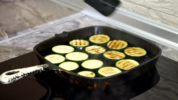 Szakács grill cukkini grill serpenyőben, és fordítsa meg őket fogóval — Stock videók