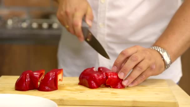 Amatér kuchař řezy Bell pepper na dřevěné sekání palubě v kuchyni zblízka — Stock video