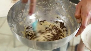 Şef hamura çikolata ekler ve çikolatalı kek, pasta ya da pasta yapmak için karıştırır.