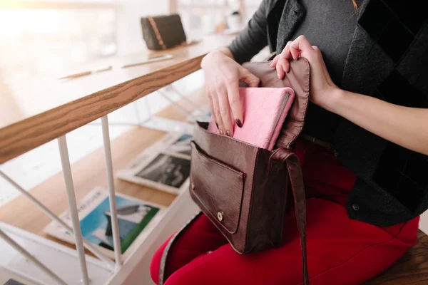 Kız bir not defteri onun çantasından çeker.