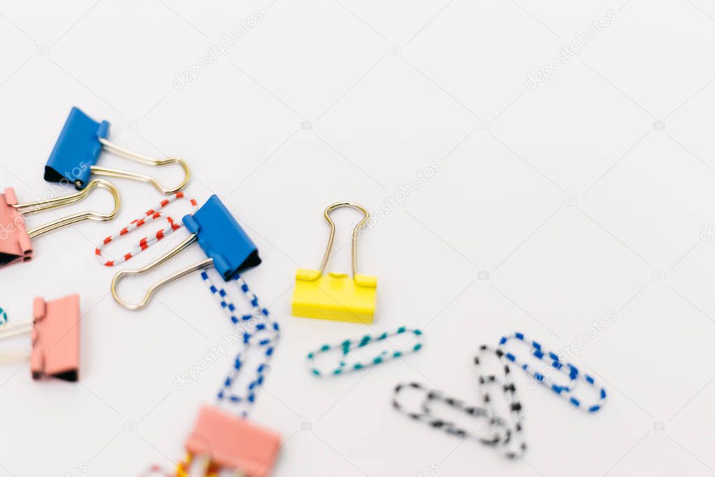 Top view of office accessories, paper clips, on white background