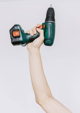 Genç bir adam bir tornavida, matkap solated elinde tutar. 