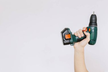 Genç bir adam bir tornavida, matkap solated elinde tutar. 