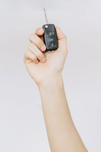 A young man holds the car keys in his hand