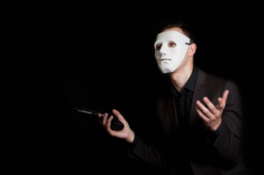 Siyah bir zemin üzerine beyaz maskeli bir adam bir silah onun h tutar.