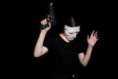 Siyah bir zemin üzerine beyaz maskeli bir kız o ile silah tutar