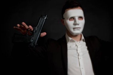 Siyah bir zemin üzerine beyaz maskeli bir adam teslim oldu, holding 