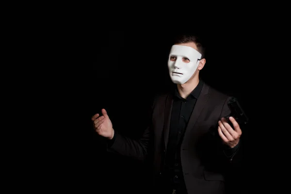 Elinde siyah bir backgro üzerinde beyaz maskeli silahlı bir adam