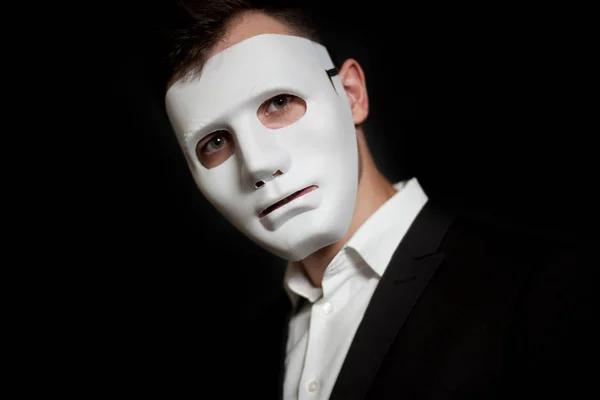 Siyah bir zemin üzerine beyaz maskeli bir adam Close-up
