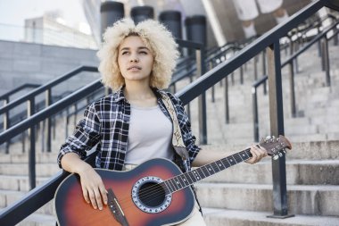 Çekici Afrikalı-Amerikalı kadın gitar ayakta sokakta oynarken