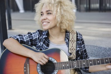 Neşeli kız sokak gitar çalmak