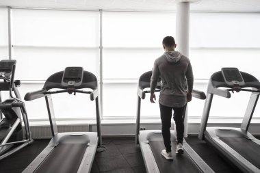 Koşu bandı üzerinde çalışan spor salonunda genç adam