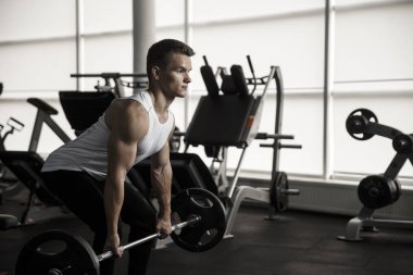 Modern bir fitness merkezi ağır deadlifts yapıyor çekici kaslı vücut geliştirmeci.