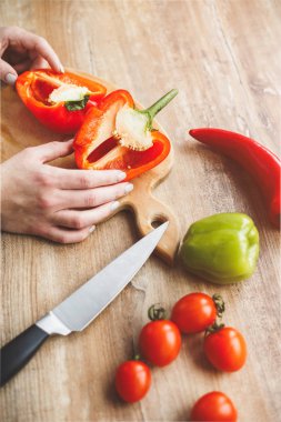 Kız biber onun elinde tutuyor. İşte biber, domates