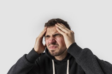 Korkunç migren muzdarip Beyaz delikanlı. Beyaz arka plan üzerinde izole. Baş ağrısı kavramı.