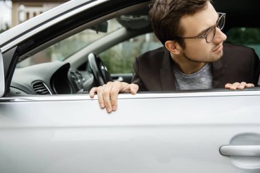 Genç adam penceresinden bakmak Dissapointed. Şey arabasının arıyor.