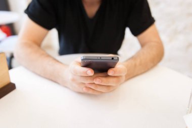 Yakışıklı, genç adam ortak bir alanda cep telefonunu kullanma