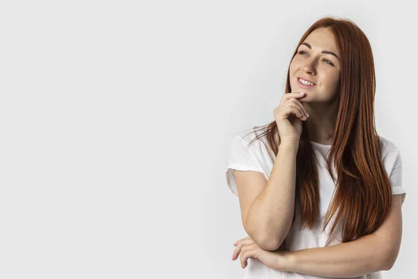 Teklifinizi tekrar edeyim. Düşünceli düşünme veya seçim yapmak çene dokunmadan ve kararlı bir ifadeyle, yukarı seyir Kızıl saçlı akıllı kız duruldu. Gri arka plan üzerinde izole