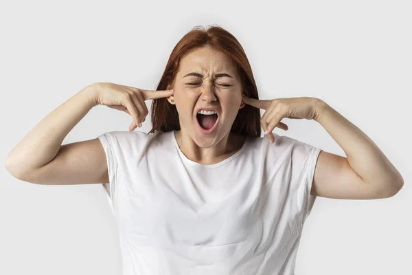 Hayal kırıklığına uğramış genç redhead parmaklarıyla kulaklarını tıkama kadın vurguladı ve having baş ağrısı, dayanamıyorum çevresinde korkunç gürültü komşular gözleri koruma kapalı