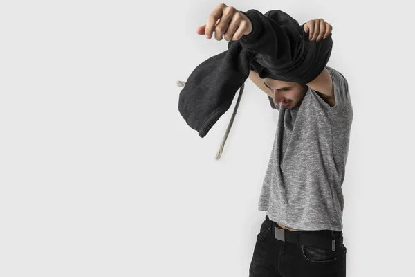 Yorgun beyaz genç adam mutlu uzun ve yoğun bir günün ardından elbiselerini kaldırır. Beyaz arka plan üzerinde izole.