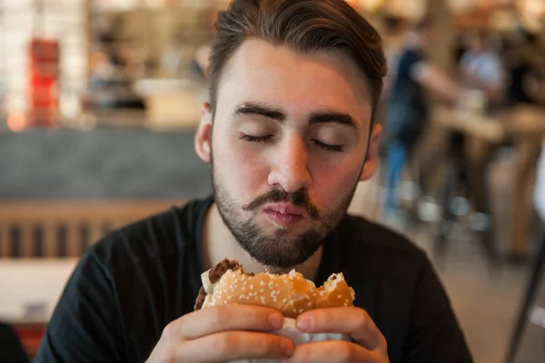 Close-up of a man chewing a burger — Stock Photo, Image