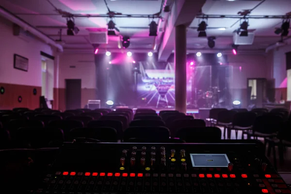 Arka planda bir rengarenk konser salonu ile büyük ses karıştırıcı.