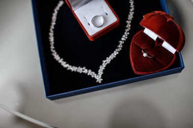 İki kırmızı halka kutu içinde onları ve onlara yakın bir kolye yüzük mavi mücevher kutusu içinde yalan söylüyorsun.