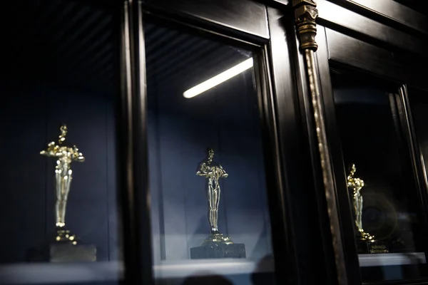 Cam vitrinde üç Oscar heykelleri. Oscar Ödülleri konsepti.