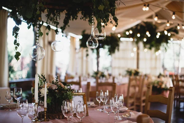 Un tavolo con tanti bicchieri da vino e un mazzo di fiori. Restauraunt terrazza sullo sfondo . — Foto Stock