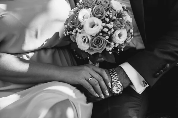 Bir erkek ve bir kadın eller closeup düzenliyoruz. Bir kadın çiçek buketi tutuyor.