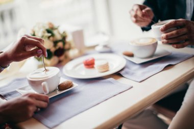 Bir iki el insanlar kafede oturan ve kahve closeup içme.