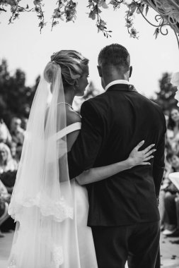 Damat ve gelin konuk önünde çiçek kemer altında duran.