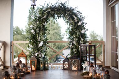 Lanters yanında yanan bir sürü ile bir çiçek kemer.