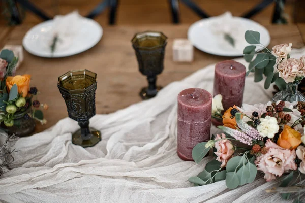 两个酒杯和几个蜡烛站在桌子上, 桌子上放着一些花在锅里. — 图库照片