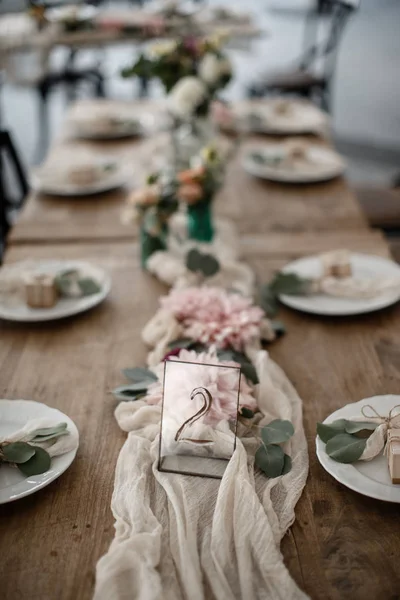 A lots of cutlery and some decorations are laying at the table alongside with a number 2 sign. — Stock Photo, Image