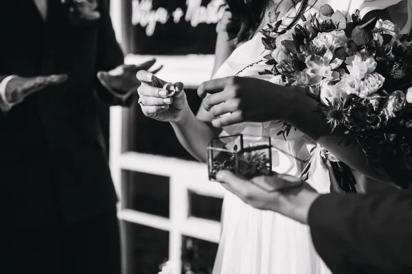 新娘在手指上戴了一枚戒指。拿着戒指盒的手在前景. — 图库照片