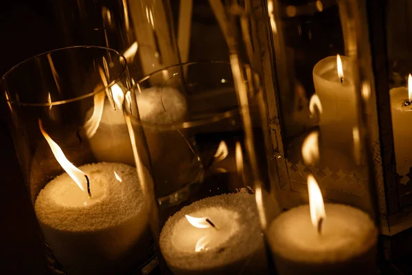 Muitas velas estão queimando dentro dos óculos de vela . — Fotografia de Stock