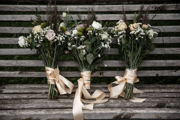三束花束和一条丝带站在长凳上. — 图库照片