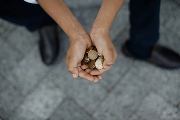 Adam bir avuç paraları closeup tutuyorsun.